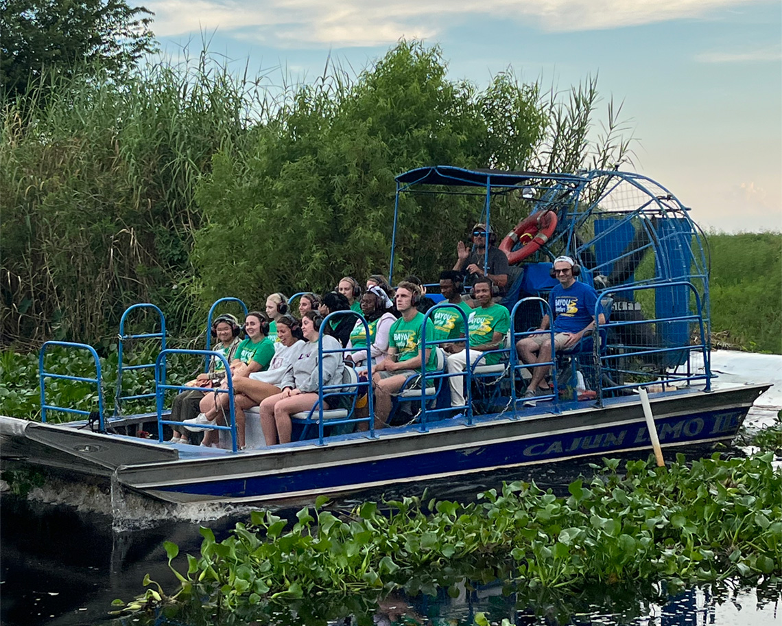 people in an airboat in a swamp