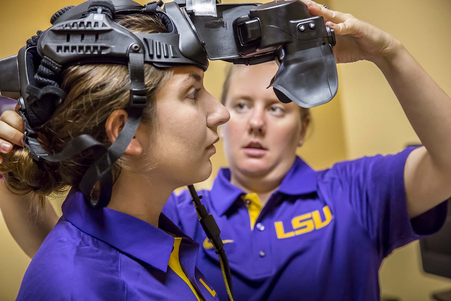 woman fitting a virtual reality mask on another woman