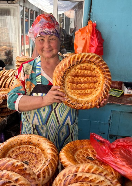 Woman holding nan bread stamped with intricate patterns